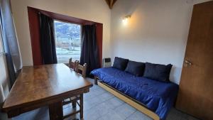 a living room with a blue couch and a table at Hospedaje Melincue Chalten in El Chalten