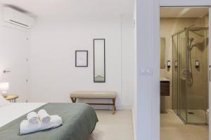 a white bedroom with a bed and a shower at Royar Apartamentos in Jaén +22 photos