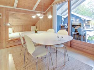 a dining room with a white table and chairs at Holiday Home Anttoni - 50km from the sea by Interhome in Ansager
