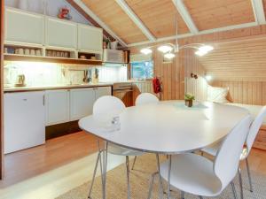 a kitchen with a white table and white chairs at Holiday Home Anttoni - 50km from the sea by Interhome in Ansager