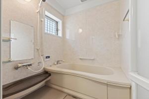 a bathroom with a tub and a mirror at Panoramic Kamo River View Stay with Serene Sounds in Kyōto +43 photos