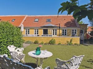 a table and chairs in front of a house at Holiday Home Algeth - 200m from the sea by Interhome in Skagen