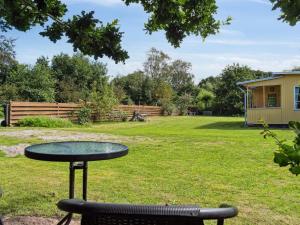 a table and a chair in a yard at Holiday Home Aslak - 600m from the sea by Interhome in Glesborg