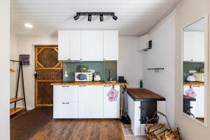 a kitchen with white cabinets and a wooden floor at Historic Manor Apartment in Kuressaare