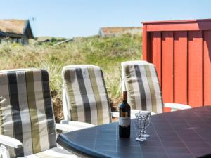 a bottle of wine sitting on a table with chairs at Holiday Home Kirsten - 800m from the sea by Interhome in Henne Strand
