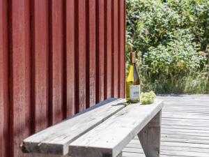 a bottle of wine sitting on top of a wooden bench at Holiday Home Kirsten - 800m from the sea by Interhome in Henne Strand
