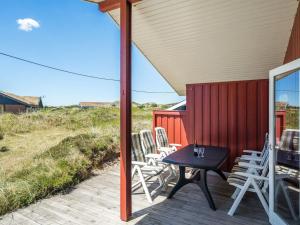 a patio with chairs and a table on a deck at Holiday Home Kirsten - 800m from the sea by Interhome in Henne Strand