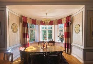 a dining room with a table and chairs and a window at Vallby Herrgård in Mariestad