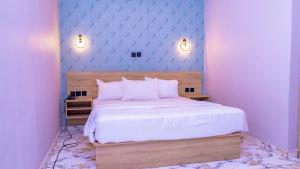 a bedroom with a large bed with purple walls at H3 Hotel and Events Centre in Abeokuta
