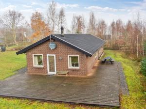 a small brick house with a wooden deck at Holiday Home Patrik - 200m to the fjord by Interhome in Fur