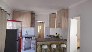 a kitchen with wooden cabinets and a black refrigerator at Mooi Nooi in Beaufort West