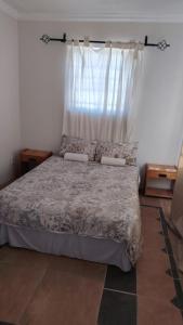 Un dormitorio con una cama grande con ventana. en Mooi Nooi, en Beaufort West