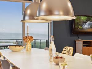 a dining room with a table with a bottle of wine at Holiday Home Berta - 70m to the fjord by Interhome in Roslev