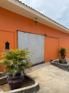 ein orangefarbenes Gebäude mit einer großen Tür und einigen Pflanzen in der Unterkunft Casa Calleb in Presidente Figueiredo + 20 Fotos