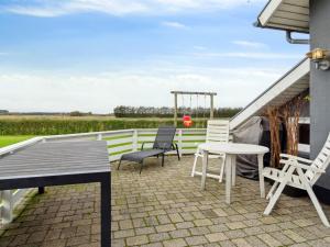a patio with chairs and a table and a gazebo at Holiday Home Thrugels - 600m from the sea by Interhome in Hadsund