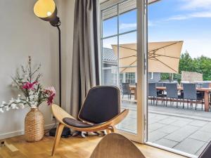ein Stuhl und eine Lampe in einem Raum mit einer Terrasse in der Unterkunft Holiday Home Ronia - 900m from the sea by Interhome in Bøtø By + 45 Fotos
