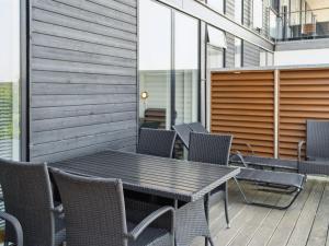 a wooden table and chairs on a patio at Apartment Kimi - 100m from the sea by Interhome in Havneby +19 photos