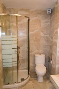 a bathroom with a toilet and a glass shower at Ippotamos House in Agios Nikolaos
