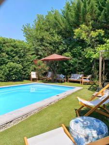 einen Pool mit Liegestühlen und einem Sonnenschirm in der Unterkunft Proche Carcassone chambre avec salle de bain et WC privée Piscine salon et kitchenette partagés avec voyageurs in Cépie
