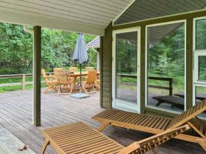 a screened in porch with a table and chairs at Holiday Home Ellynor - 600m from the sea by Interhome in Neksø