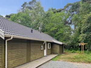a wooden cabin with a wooden ramp next to a cross at Holiday Home Ellynor - 600m from the sea by Interhome in Neksø