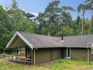 a cabin with a deck in front of a house at Holiday Home Ellynor - 600m from the sea by Interhome in Neksø