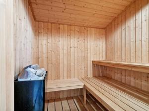 a wooden sauna with a trash can in it at Holiday Home Ellynor - 600m from the sea by Interhome in Neksø +24 photos