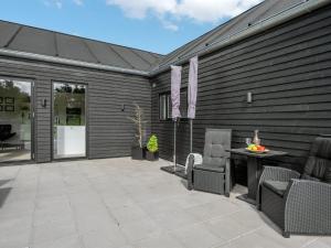 a patio with chairs and a table and a building at Holiday Home Henrikke - 500m to the fjord by Interhome in Skjern