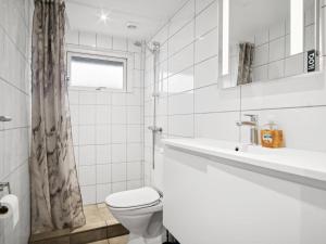 a white bathroom with a toilet and a sink at Holiday Home Ilsebet - 150m from the sea by Interhome in Børkop +7 photos