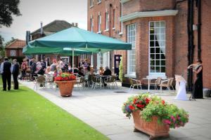a bride and groom standing in front of a building at Best Western Plus West Retford Hotel in Retford