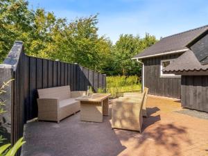 Un patio con un sofá y sillas y una mesa. en Holiday Home Roska - 1-3km from the sea by Interhome, en Saltum