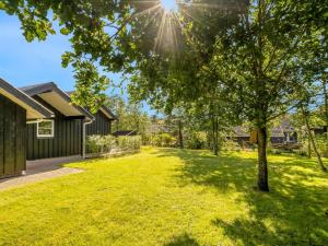un patio con un árbol y una casa en Holiday Home Roska - 1-3km from the sea by Interhome, en Saltum 16 fotos más