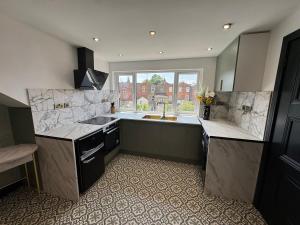 a large kitchen with a sink and a window at Green Gable Hideaway in Gloucestershire