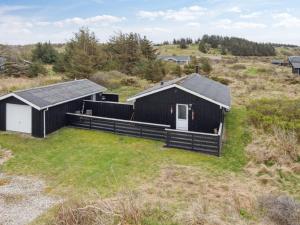 una vista aerea di una casa nera in un campo di Holiday Home Zina - 600m from the sea by Interhome a Hjørring