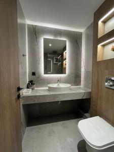 un bagno con lavandino, WC e specchio di 7th floor Studio a Xánthi