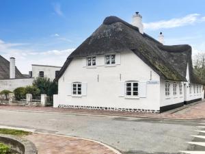 an old white building with a thatched roof at Holiday Home Maelle - 25km from the sea by Interhome in Højer