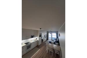 a kitchen with white cabinets and a table and chairs at Snowflake XI Family rooms in Rovaniemi