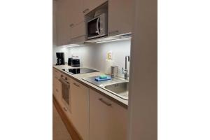 a kitchen with a sink and a microwave at Snowflake XI Family rooms in Rovaniemi +2 photos