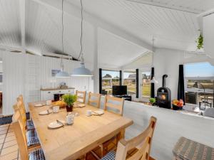 Una cocina y un comedor con mesa y sillas de madera. en Holiday Home Josef - 950m from the sea by Interhome, en Fanø