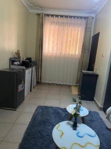 una sala de estar con una mesa sobre una alfombra azul en Ciara's Home Entebbe, en Entebbe