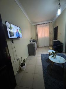 a living room with a flat screen tv on the wall at Ciara's Home Entebbe in Entebbe