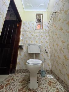 a bathroom with a white toilet in a room at Ciara's Home Entebbe in Entebbe +8 photos