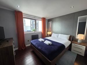 une chambre avec un grand lit avec des serviettes dessus dans l'établissement Edinburgh City Sea View Harbour Apartment, à Édimbourg