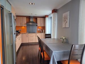 une cuisine et une salle à manger avec une table et des chaises dans l'établissement Edinburgh City Sea View Harbour Apartment, à Édimbourg