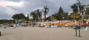 a beach with chairs and umbrellas on the sand at sri sayang apartment in Batu Ferringhi