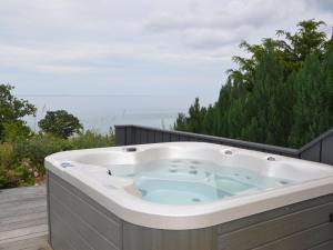 a jacuzzi tub on the deck of a house at Holiday Home Seetje - 200m from the sea by Interhome in Allinge