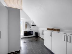 a kitchen with white cabinets and a tile floor at Holiday Home Amma - 21km from the sea by Interhome in Bredebro