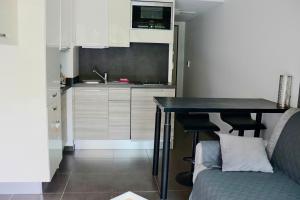 eine Küche mit einem Tisch und einer Couch in einem Zimmer in der Unterkunft côté plage in Propriano
