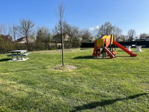 a park with a playground and a picnic table at Hébergement La Fontaine in La Coudre