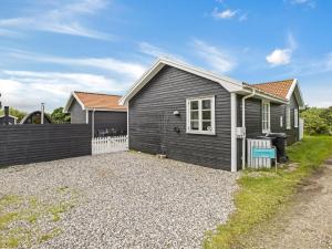a house with a gravel driveway in front of it at Holiday Home Torhild - 700m from the sea by Interhome in Ringkøbing